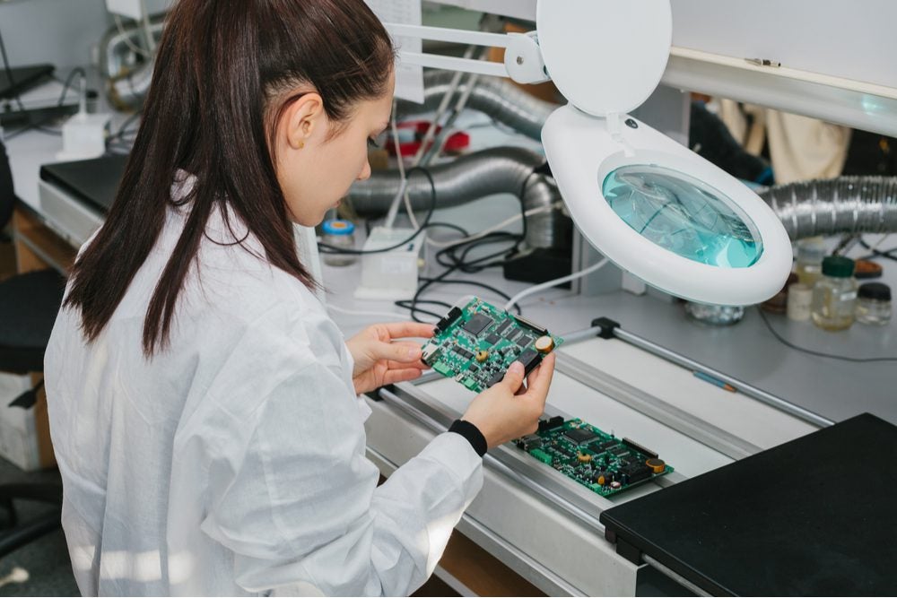 A woman assembling a circuit board.