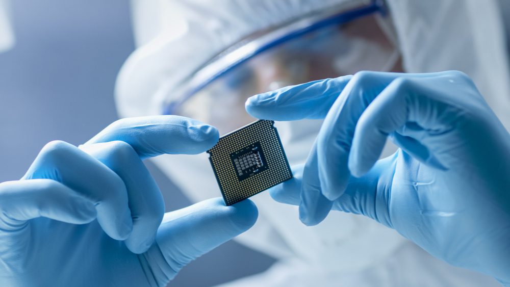 An electronics technician examining a microchip.