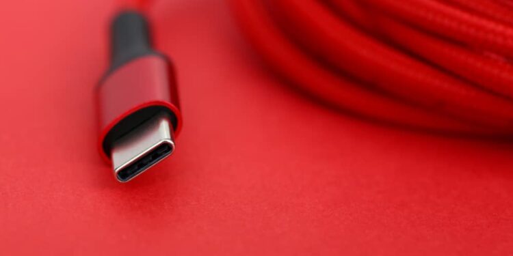 Red USB-C cable on a red background.