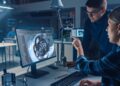 Engineers working on 3D CAD model of an engine
