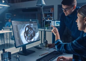 Engineers working on 3D CAD model of an engine